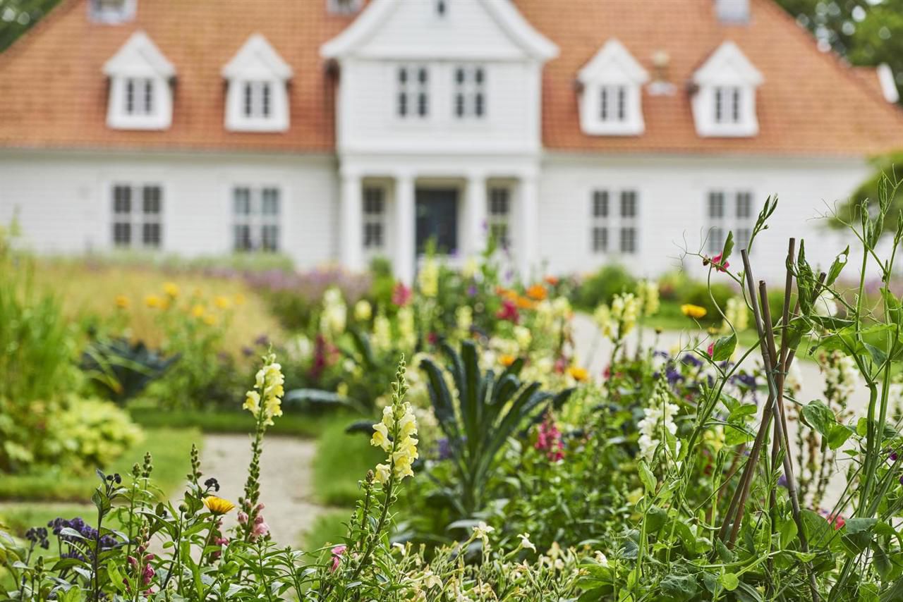 Bildet viser den historiske hagen med hovedbygning i bakgrunnen