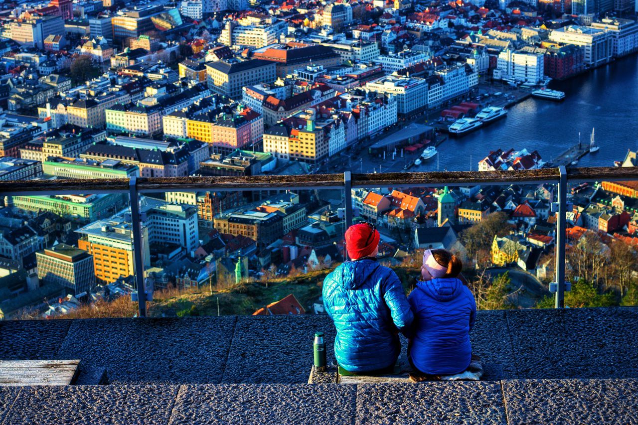 Bildet viser to personer som sitter og ser utover Bergen sentrum