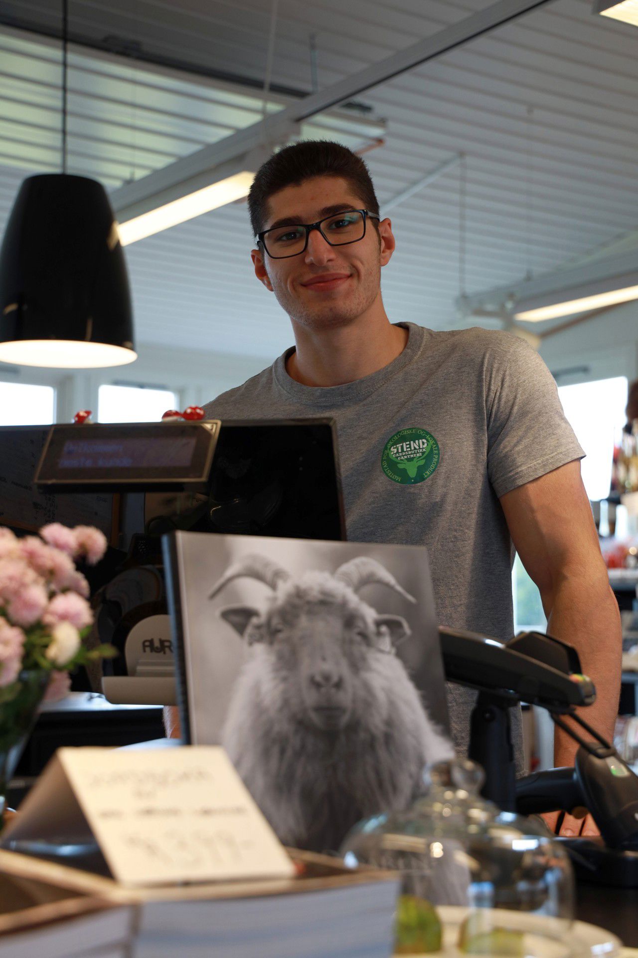 Bildet viser en elev i kassen på gardsbutikken.
